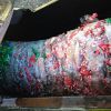 El embalaje de las botellas de platico saliendo compactado del compactador de tornillo